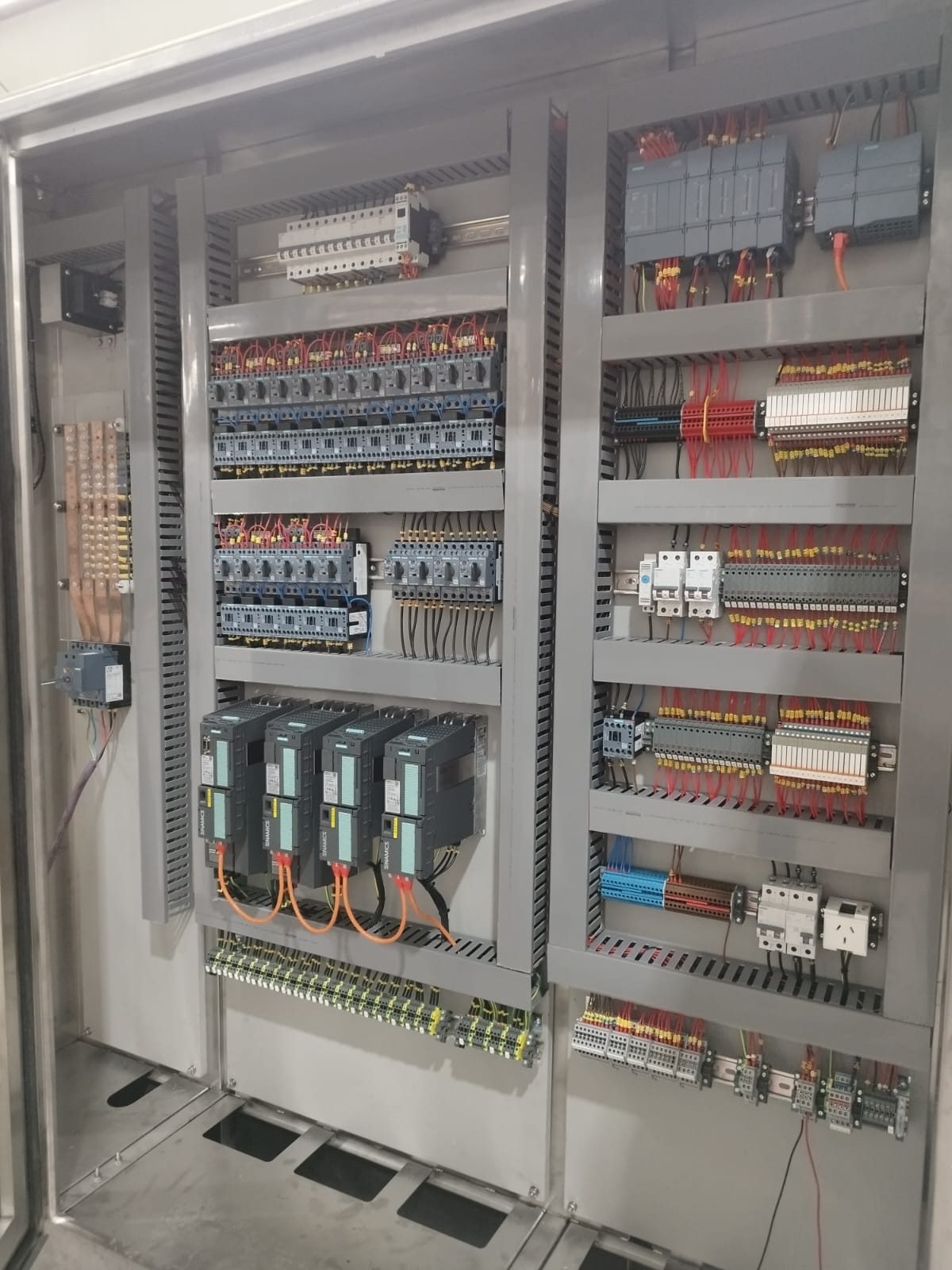 Interior de tablero de comando con variadores Siemens, contactores y bornes, puerta abierta