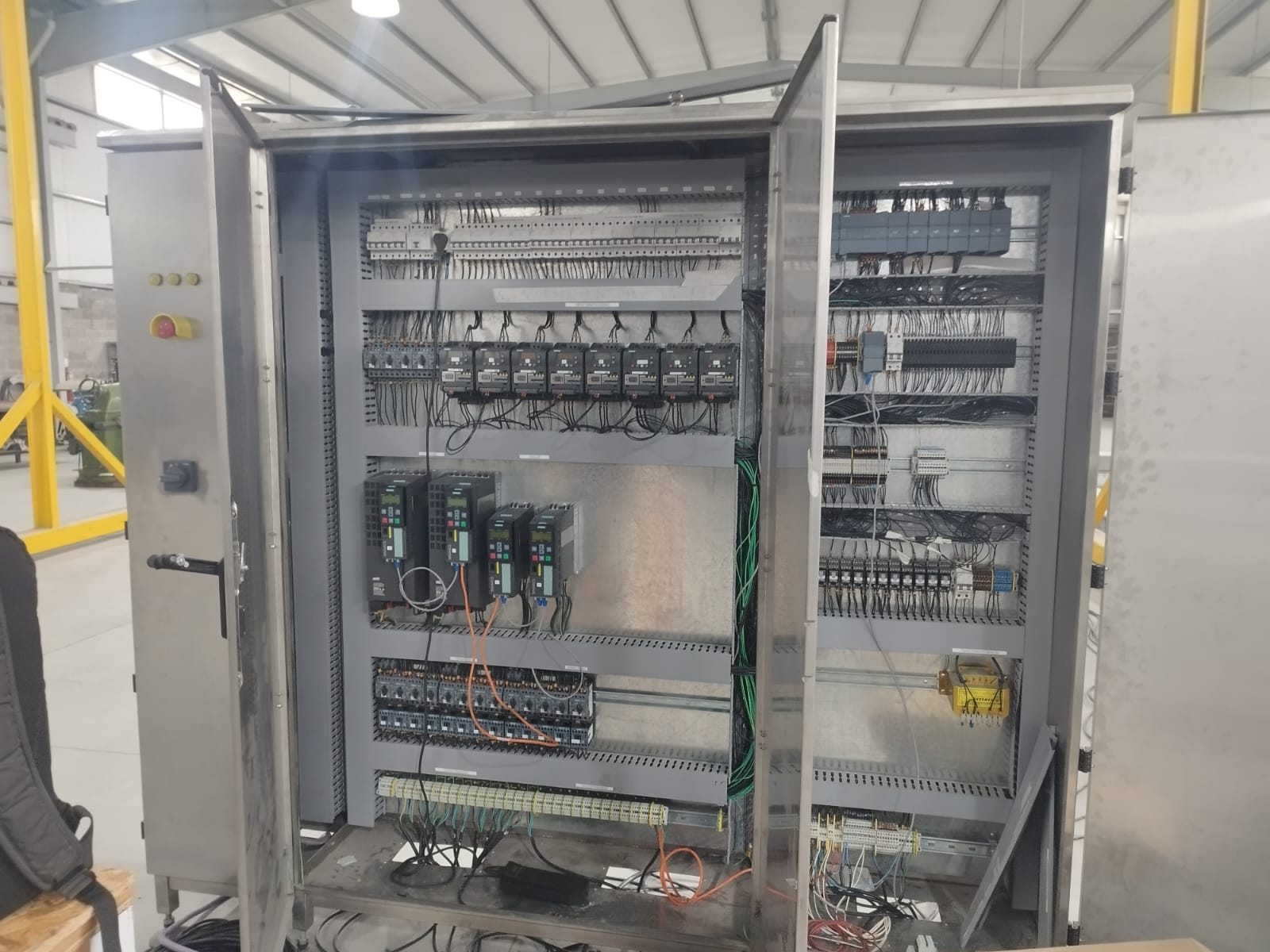 Tablero de acero inoxidable con puertas abiertas, variadores Siemens y protecciones