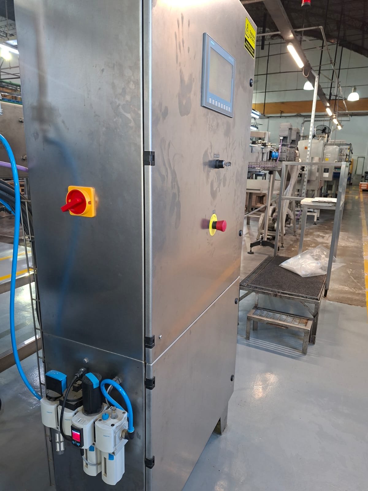 Tablero de acero inoxidable con HMI, seccionador y FRL en planta de alimentos